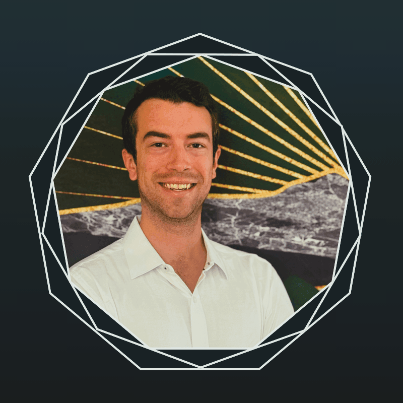 Smiling man in a white shirt centered within a white geometric circular frame pattern.